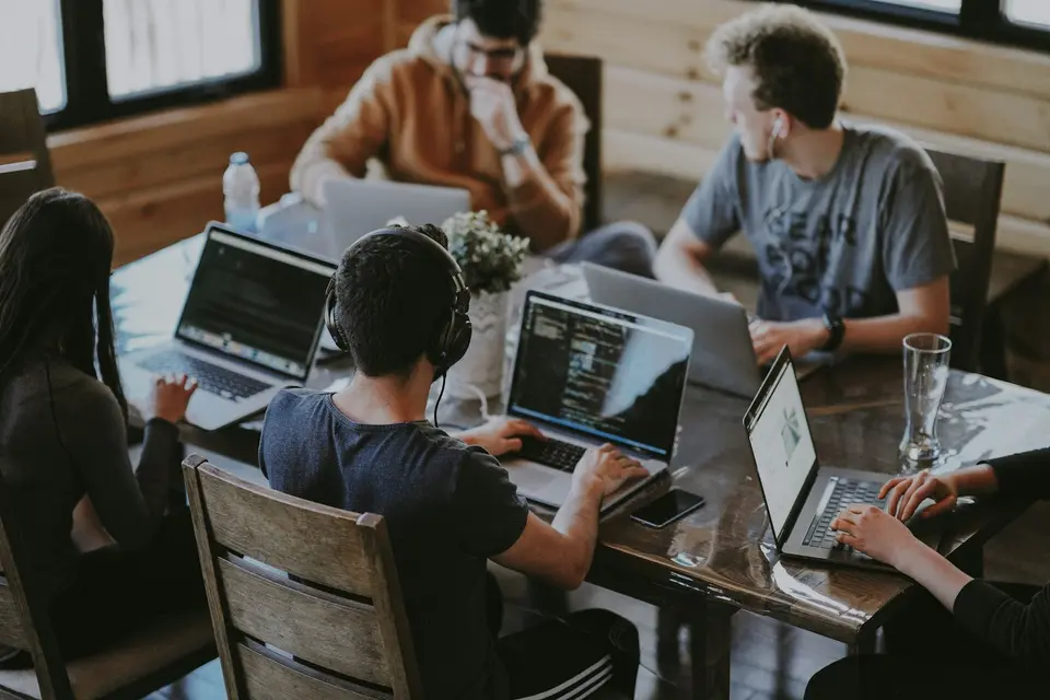 A young team working together on laptops around a table